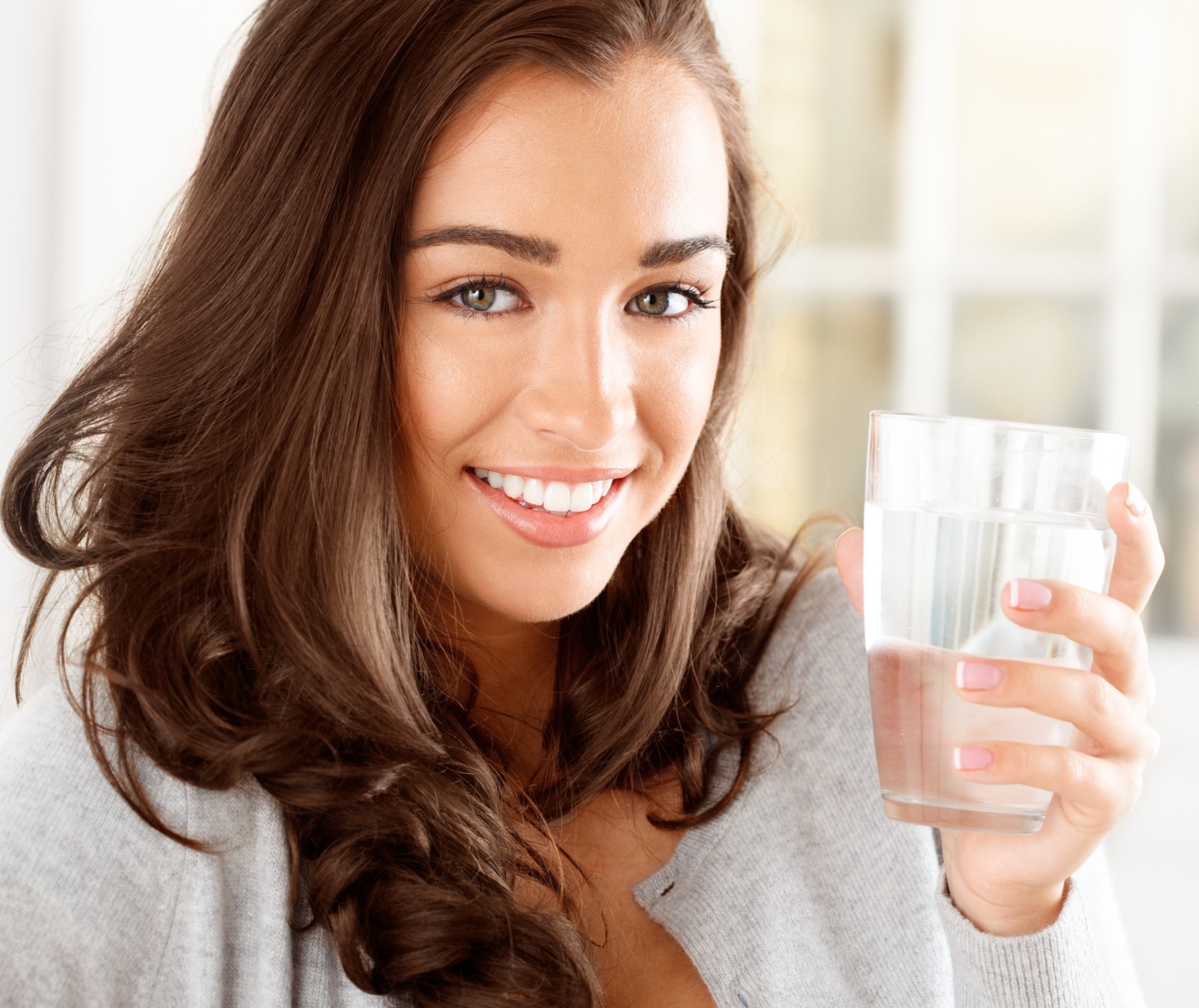 smiling woman holding a glass of water