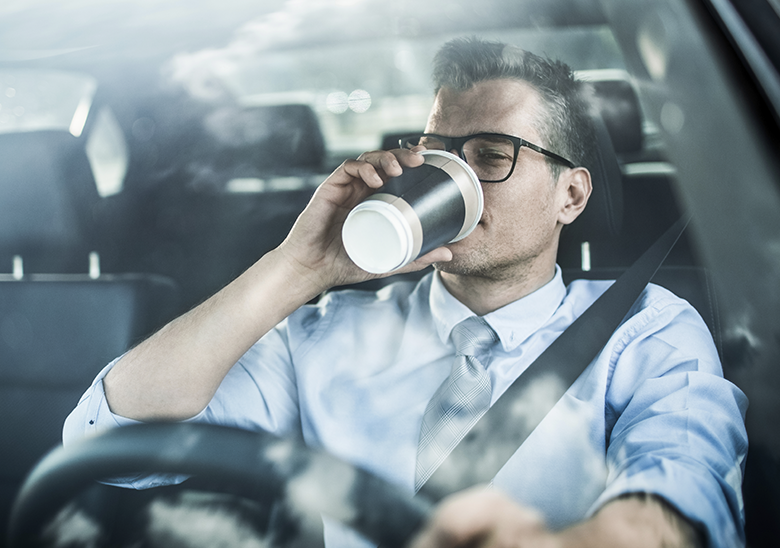 man driving with coffee