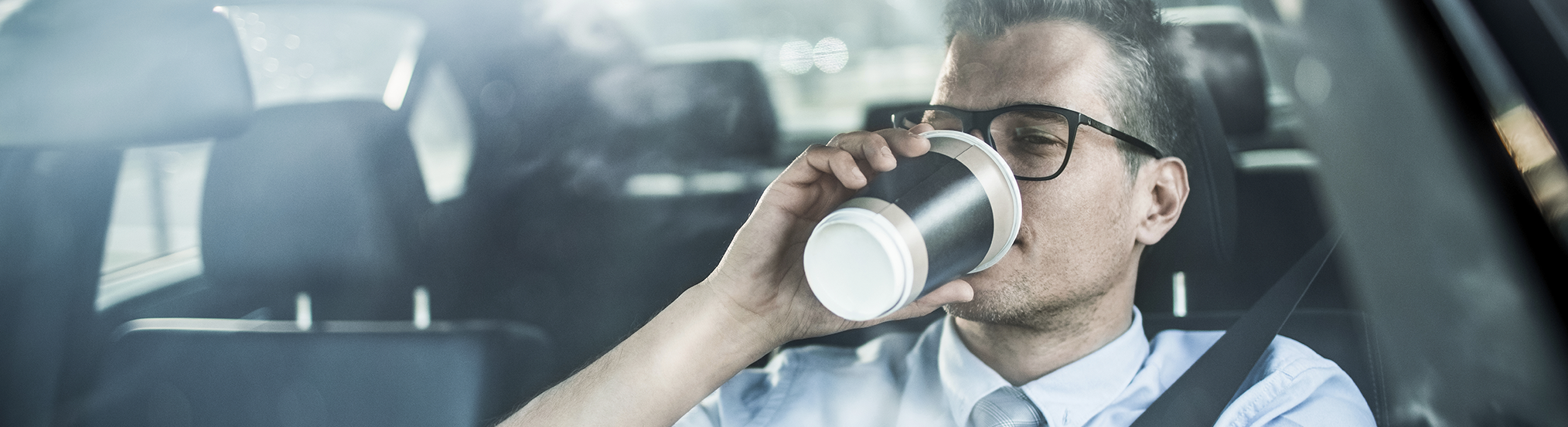 man driving with coffee