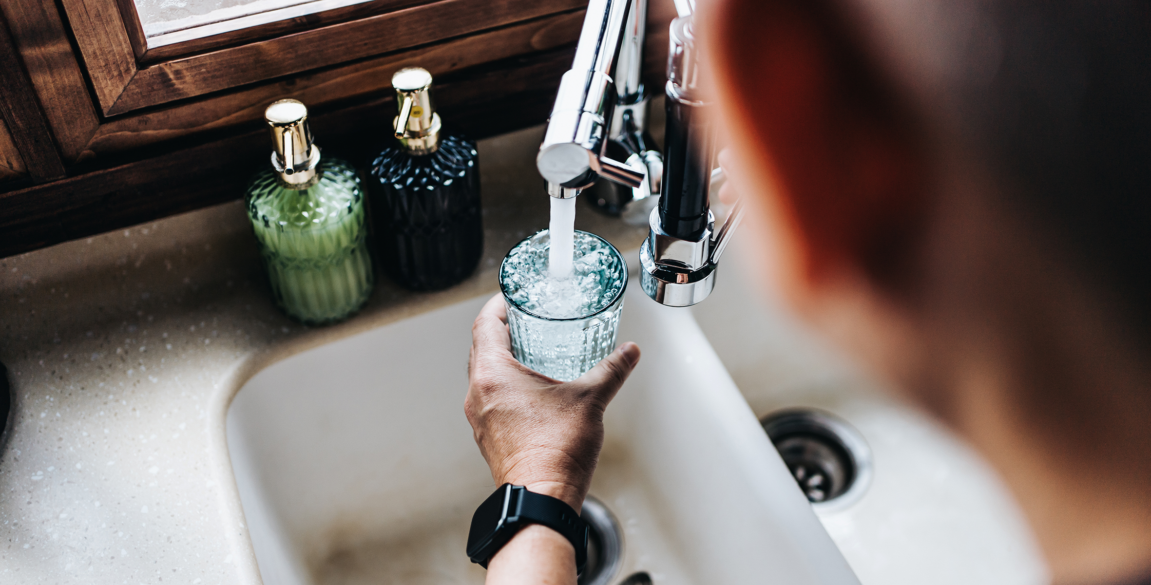 man filling himself a glass of water